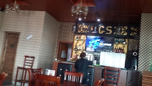 A bar area with a counter, chairs, and a chandelier. - SGS Hotel (Addis Ababa)