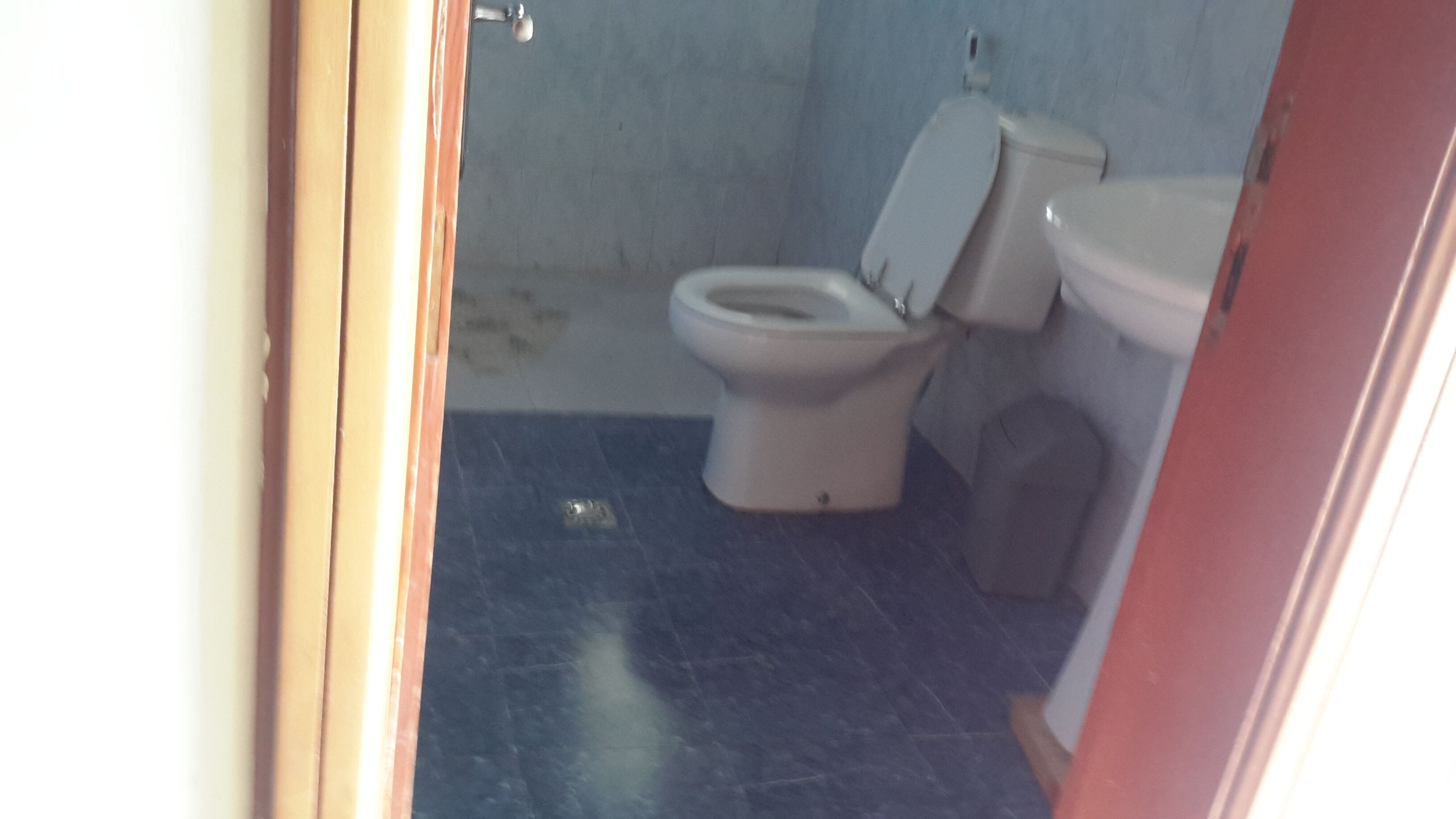 Un baño con inodoro, lavamanos y zona de ducha.