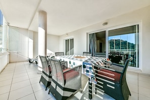 A balcony with a dining table and chairs, large windows, and a view of the outdoors. - Beautiful apartment with sea views in Altea Hills / Ref 1092 Elena Hills (Altea)