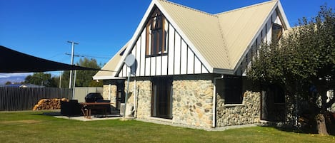 A stone house with a gabled roof and a satellite dish.