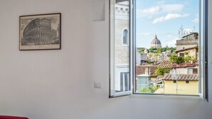 A room with a large window offering a view of a historic dome and surrounding buildings. - Modern studio with panoramic terrace, by Campo de’ Fiori - Wifi, Independent Heating, A/C (Roma)