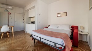 A bedroom with a bed, a desk, a chair, and a wardrobe. - Modern studio with panoramic terrace, by Campo de’ Fiori - Wifi, Independent Heating, A/C (Roma)