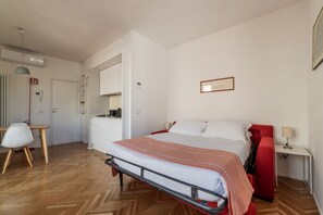 A bedroom with a bed, a desk, a chair, and a wardrobe.