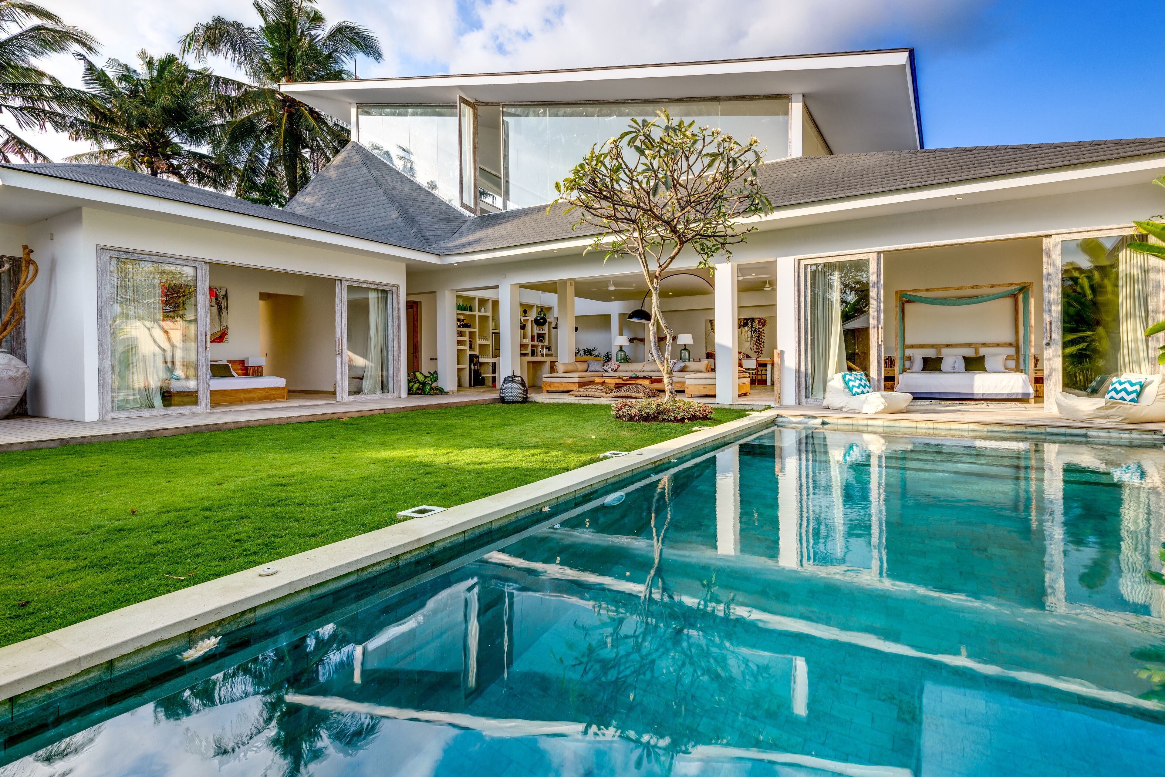 A modern house with a swimming pool, open-plan living areas, and large windows.