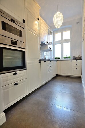 Enjoy cooking in this well-equipped kitchen with an oven, sleek cabinetry, and a pendant light above the island.