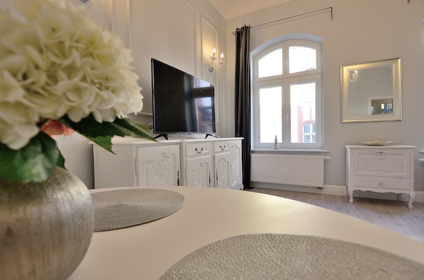 Enjoy a stylish stay with a large flat-screen TV, arched window, and comfortable bedside table.