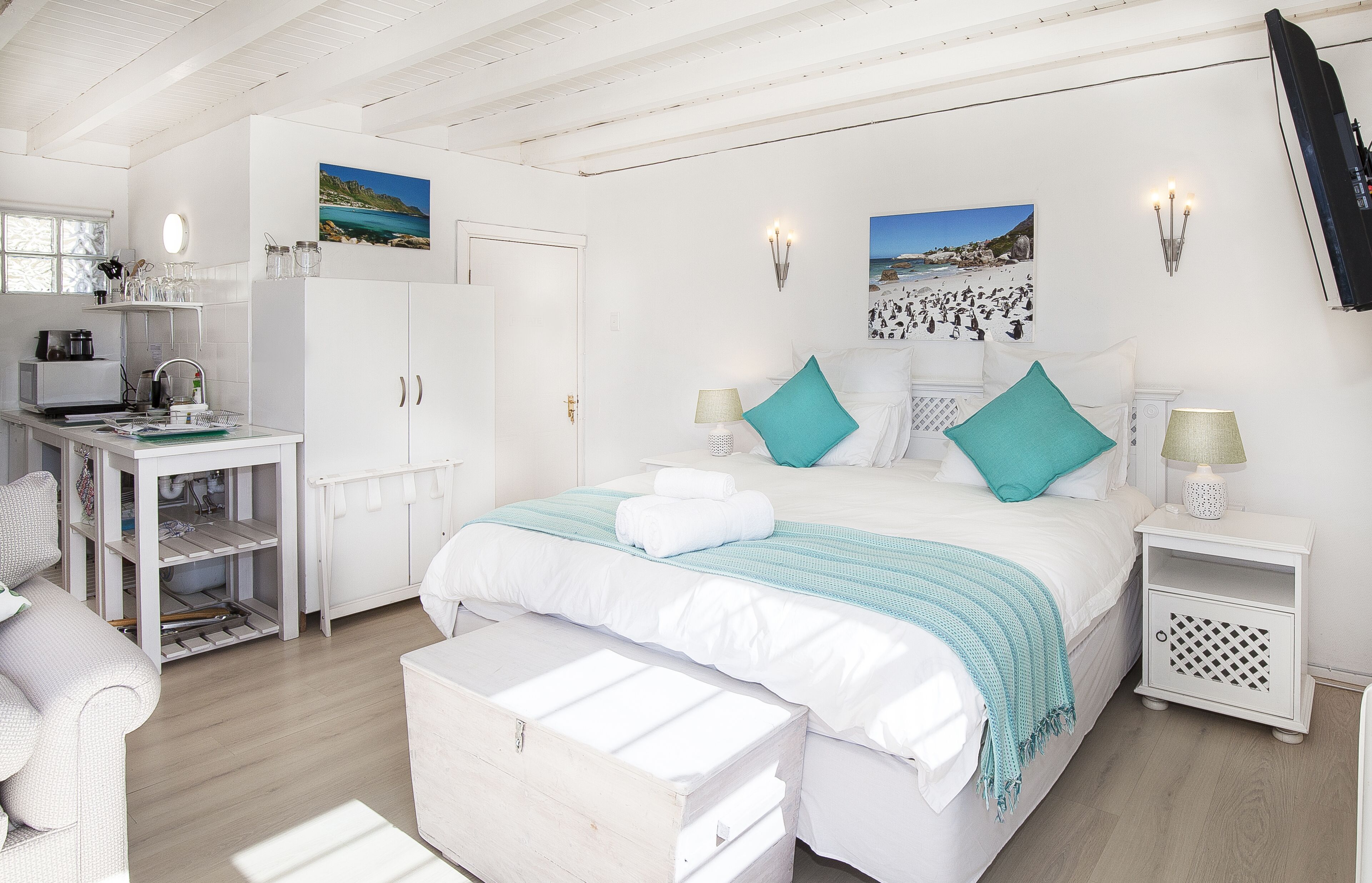 A bedroom with a bed, bedside tables, a desk, and a wardrobe.