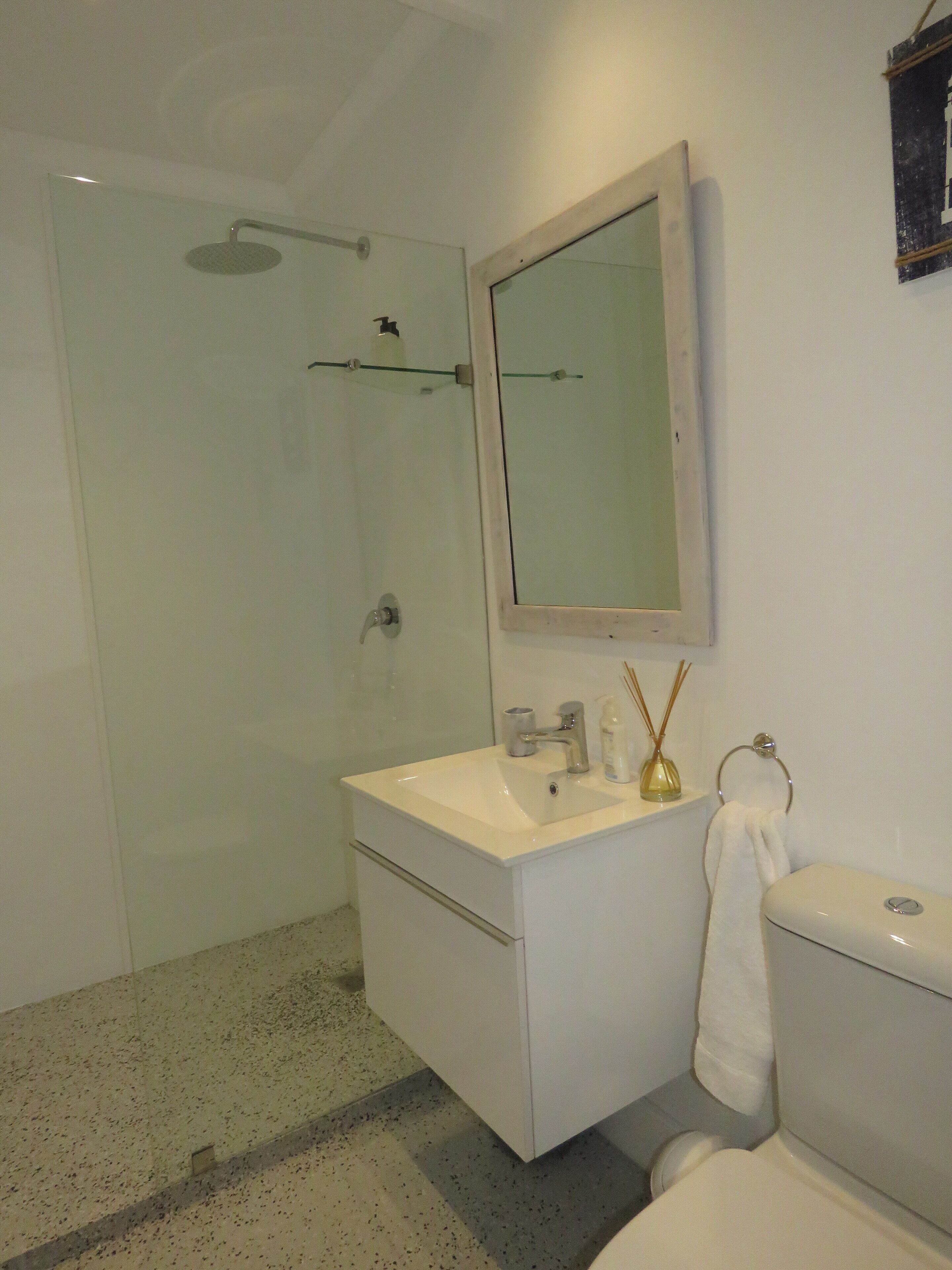 A bathroom with a shower, sink, and toilet.