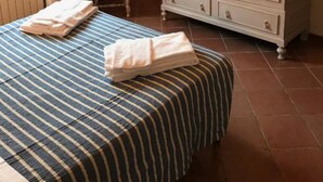 A bedroom with a bed, a chair, a wardrobe, and a radiator. - Frantoio-Large and Beautiful family apartment -Agriturismo San Jacopo (Reggello)