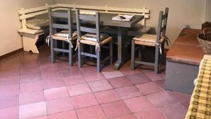A dining area with a table and chairs, a picture on the wall, and a tiled floor. - Frantoio-Large and Beautiful family apartment -Agriturismo San Jacopo (Reggello)