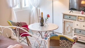 A cozy room with a round table, a television, and a cabinet with drawers. - Old City Studios 2 - Adults only (Pula)
