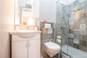 Shower, pengering rambut, sandal, dan handuk
