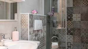 A bathroom with a white sink, toilet, and glass-enclosed shower. - Old City Studios 2 - Adults only (Pula)