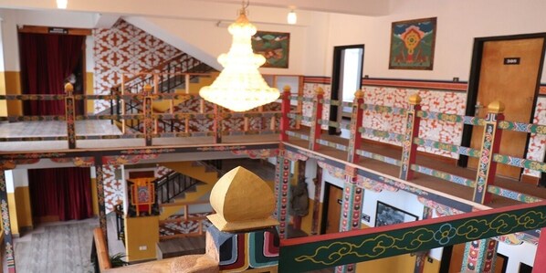A multi-level interior with a staircase, a chandelier, and a door with a number.