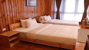 A wooden-paneled room with two beds, a nightstand, and a chair. - Hotel River Valley (Thimphu)