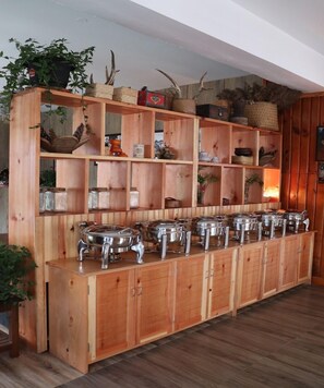 A buffet setup with multiple serving stations and a variety of decorative items on shelves.