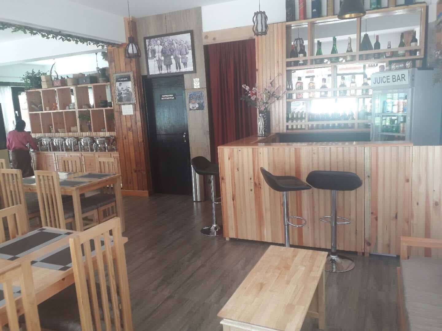 A restaurant interior with wooden furniture, a bar area, and a juice bar.