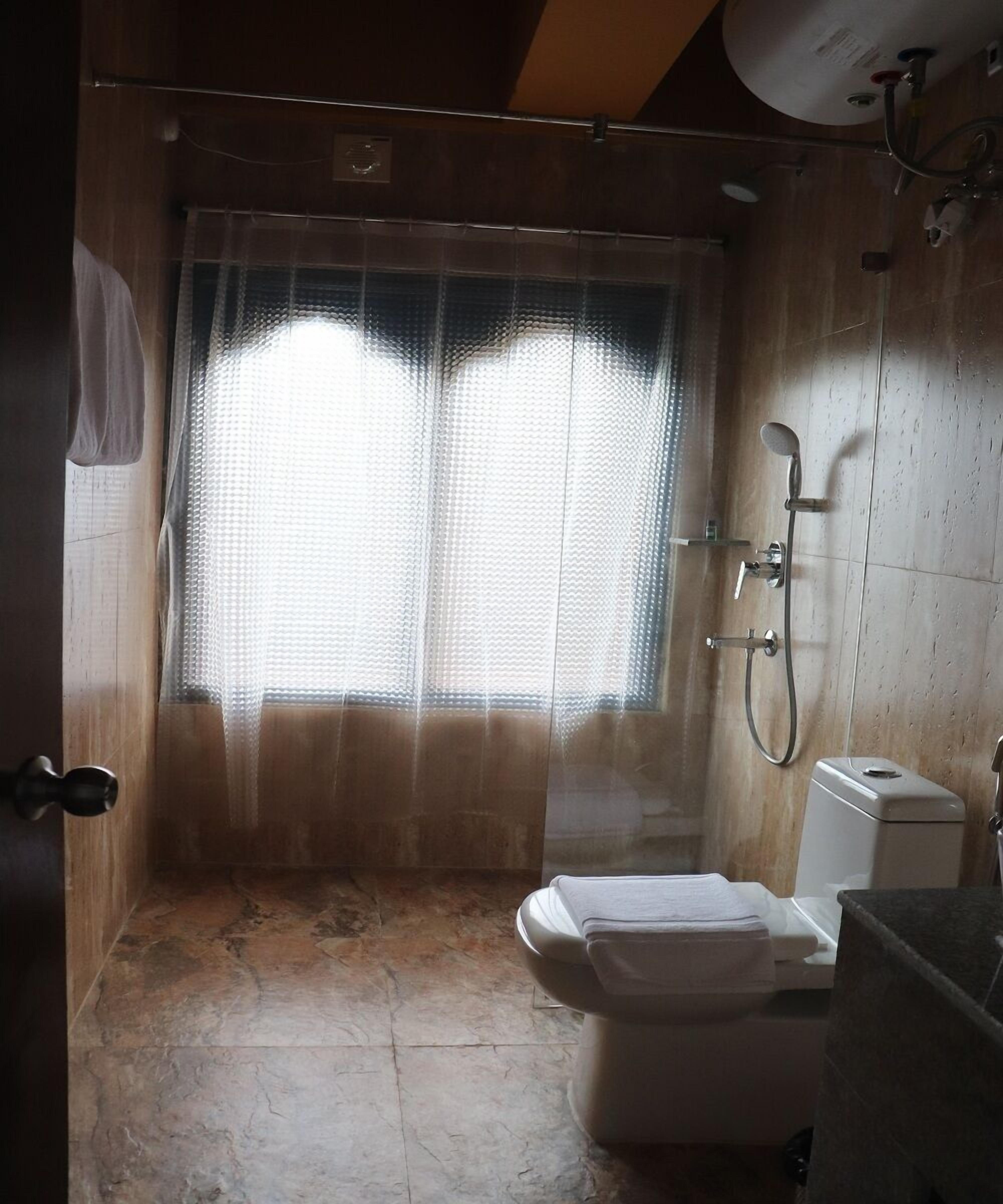 A bathroom with a shower, toilet, and sink.