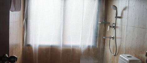 A bathroom with a shower, toilet, and sink.