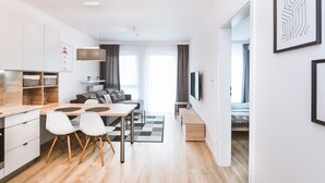Een modern appartement met goede verlichting, voorzien van een keuken, een eetgedeelte en een woonkamer.