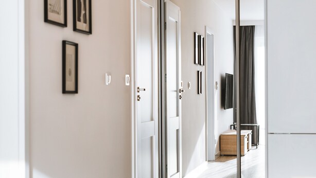 Een modern interieur met een houten vloer, een glazen deur naar een badkamer en een wandmontage tv.