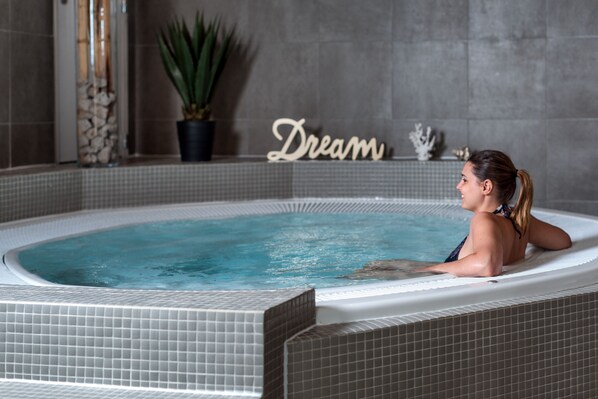 A woman in a hot tub with a 'Dream' sign in the background. - SOWELL COLLECTION Hôtel du Roi & SPA (Carcassonne)