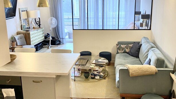 A modern living room with a sofa, coffee table, and a dining area with a table and chairs. - Small zen and cozy loft with well decorated terrace (Paris)