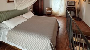 A bedroom with a bed, a chair, a desk, a lamp, and a ceiling fan. - Vinsantaia-Cozy barn on 2 levels (Reggello)