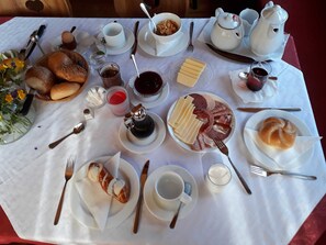 A breakfast table with various food items, utensils, and a teapot. - Double room new (type A) Z-NR. 4 - Greber Christine - Bed and breakfast (Schoppernau)