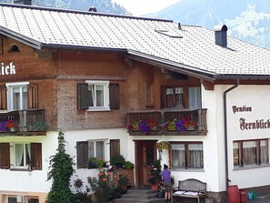 A traditional chalet with a balcony, flower boxes, and a wooden bench outside. - Double room (type A) Z-NR. 1 - Greber Christine - bed and breakfast Fernblick (Schoppernau)