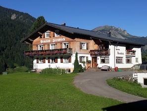Un bâtiment de style alpin traditionnel, avec une enseigne indiquant « Pension Fernblick » et un balcon agrémenté de jardinières.