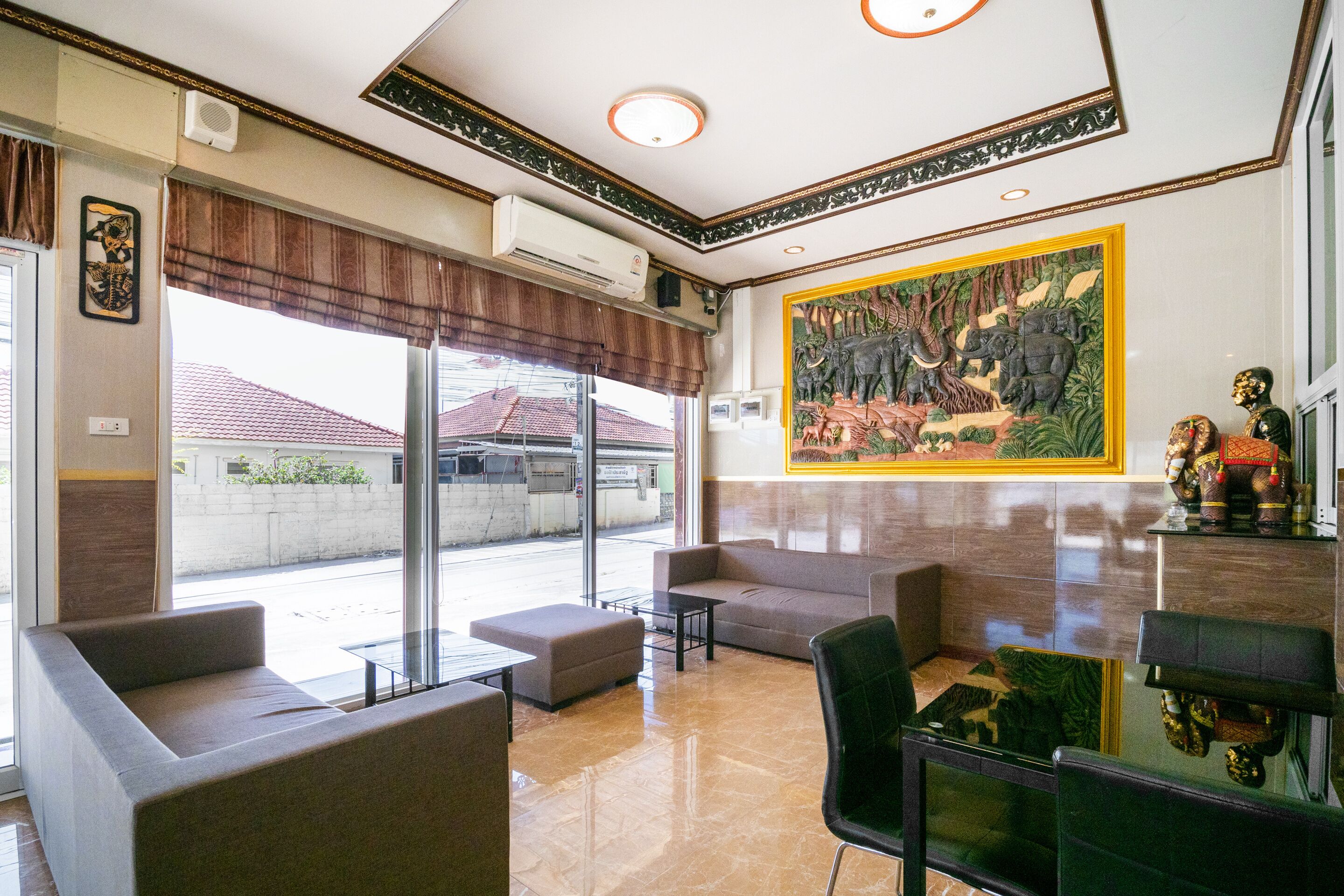 A lobby with a large window, a sofa, a chair, and a table.