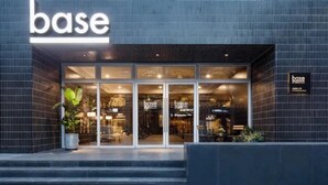 A modern building with a large 'base' sign above the entrance. - BaseLIVING Wending Serviced Apartment (Shanghai)