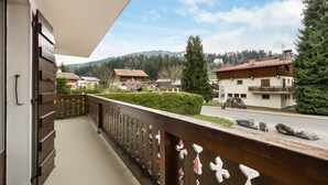 A balcony with a view of a mountain, a road, and residential buildings.