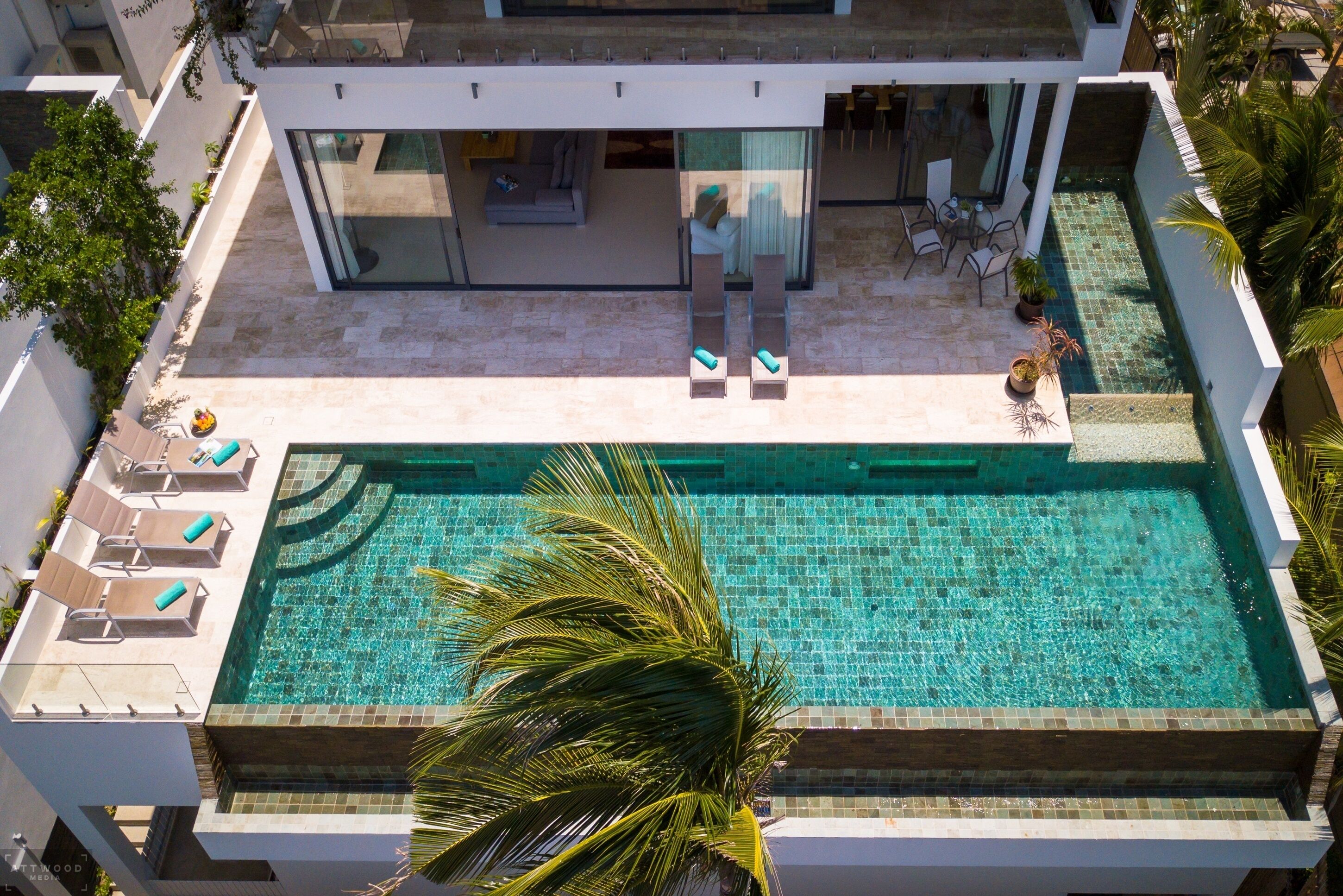 Un hotel moderno con piscina sul tetto, poltrone relax e zona ristorazione.