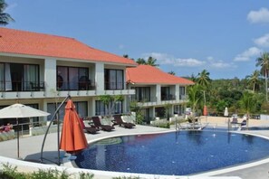 A hotel with a swimming pool, sun loungers, and a red-roofed building. - 2 Bedroom Villa Cheong Mon (Koh Samui)
