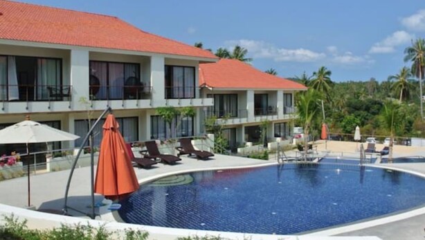 A hotel with a swimming pool, sun loungers, and a red-roofed building. - 4 Bedroom Twin Villas Cheong Mon (Koh Samui)