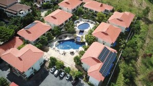 An aerial view of a residential area with multiple houses, a swimming pool, and solar panels. - 4 Bedroom Twin Villas Cheong Mon (Koh Samui)