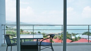 A balcony with a table and chairs, overlooking a coastal view with buildings and boats. - 6 Bedroom Sunset Sea Views Twin Apartments SDV120/097-By Samui Dream Villas (Koh Samui)