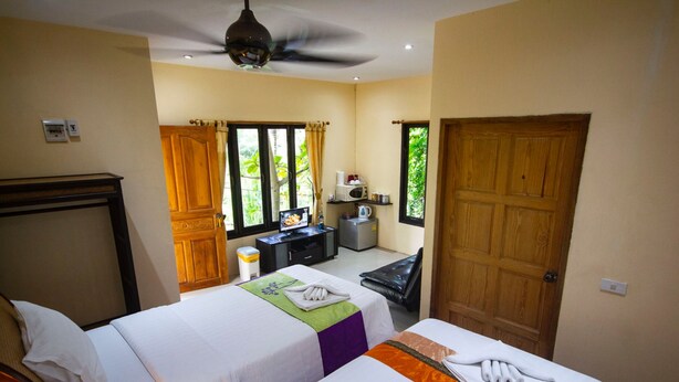 A hotel room with two beds, a desk with a computer, a microwave, and a view of greenery outside. - 1 Bedroom Beach Bungalow Koh Phangan SDV235-By Samui Dream Villas (Ko Pha-ngan)