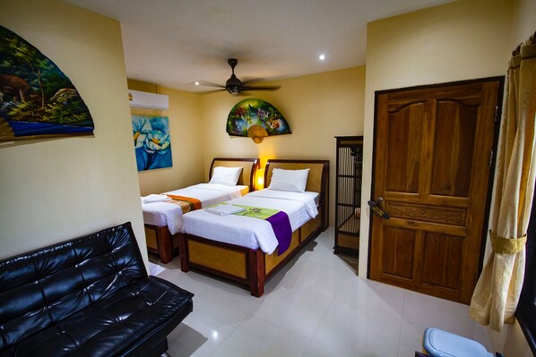 A hotel room with two single beds, a black leather sofa, a ceiling fan, and a wooden door. - 1 Bedroom Beach Bungalow Koh Phangan SDV235-By Samui Dream Villas (Ko Pha-ngan)
