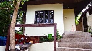 A covered outdoor area with a stone staircase leading up to a building, a table with chairs, and a small garden area. - 1 Bedroom Beach Bungalow Koh Phangan SDV235-By Samui Dream Villas (Ko Pha-ngan)