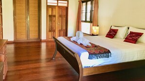 Un dormitorio con una cama grande, un armario de madera y una ventana con cortinas.