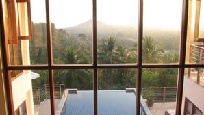 A view from a window overlooking a swimming pool with a mountainous landscape in the background. - 6 Bedroom Sea View Villas Kai Muk Mussourie (Koh Samui)
