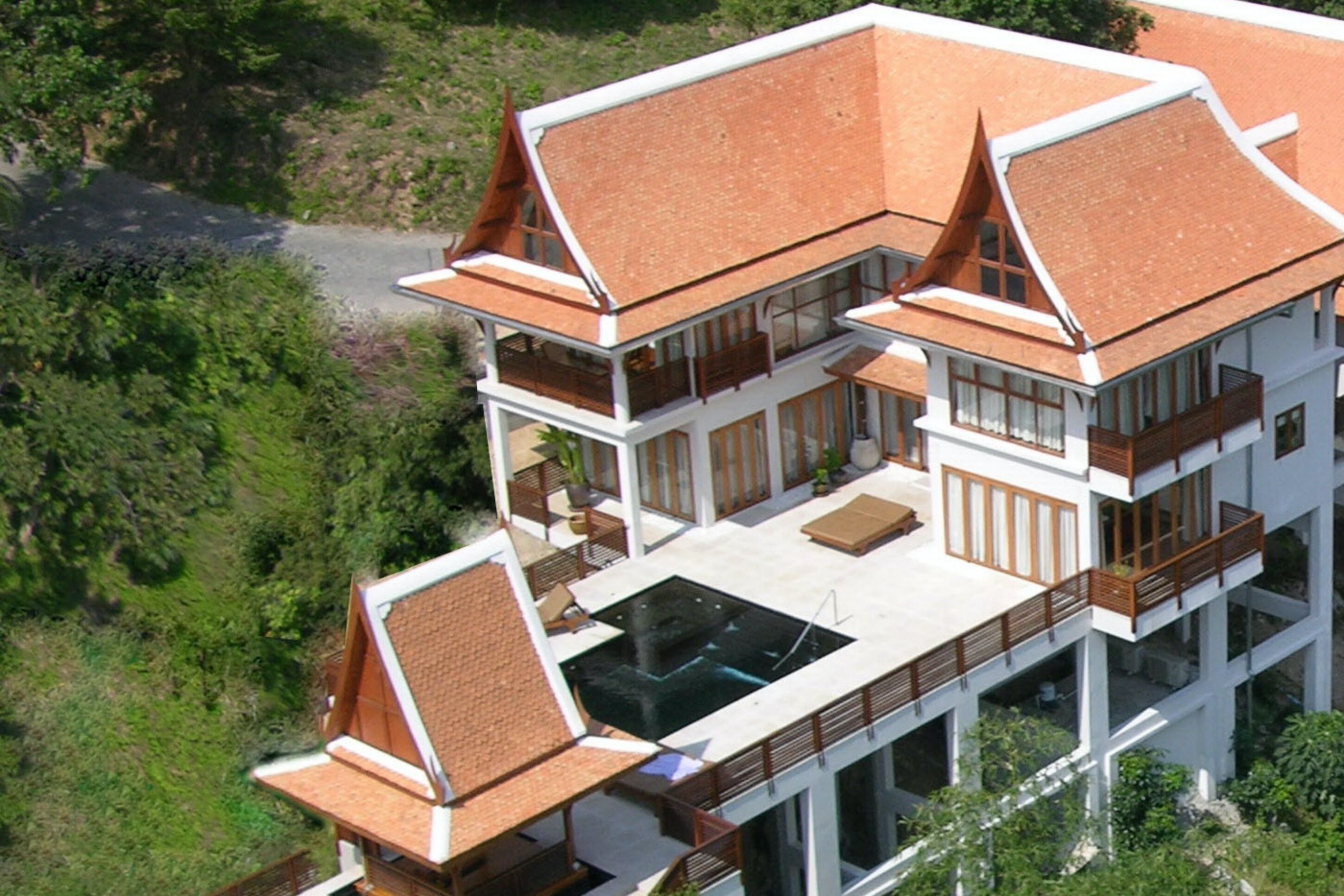 A multi-story building with a modern architectural design, featuring large windows and a rooftop swimming pool.