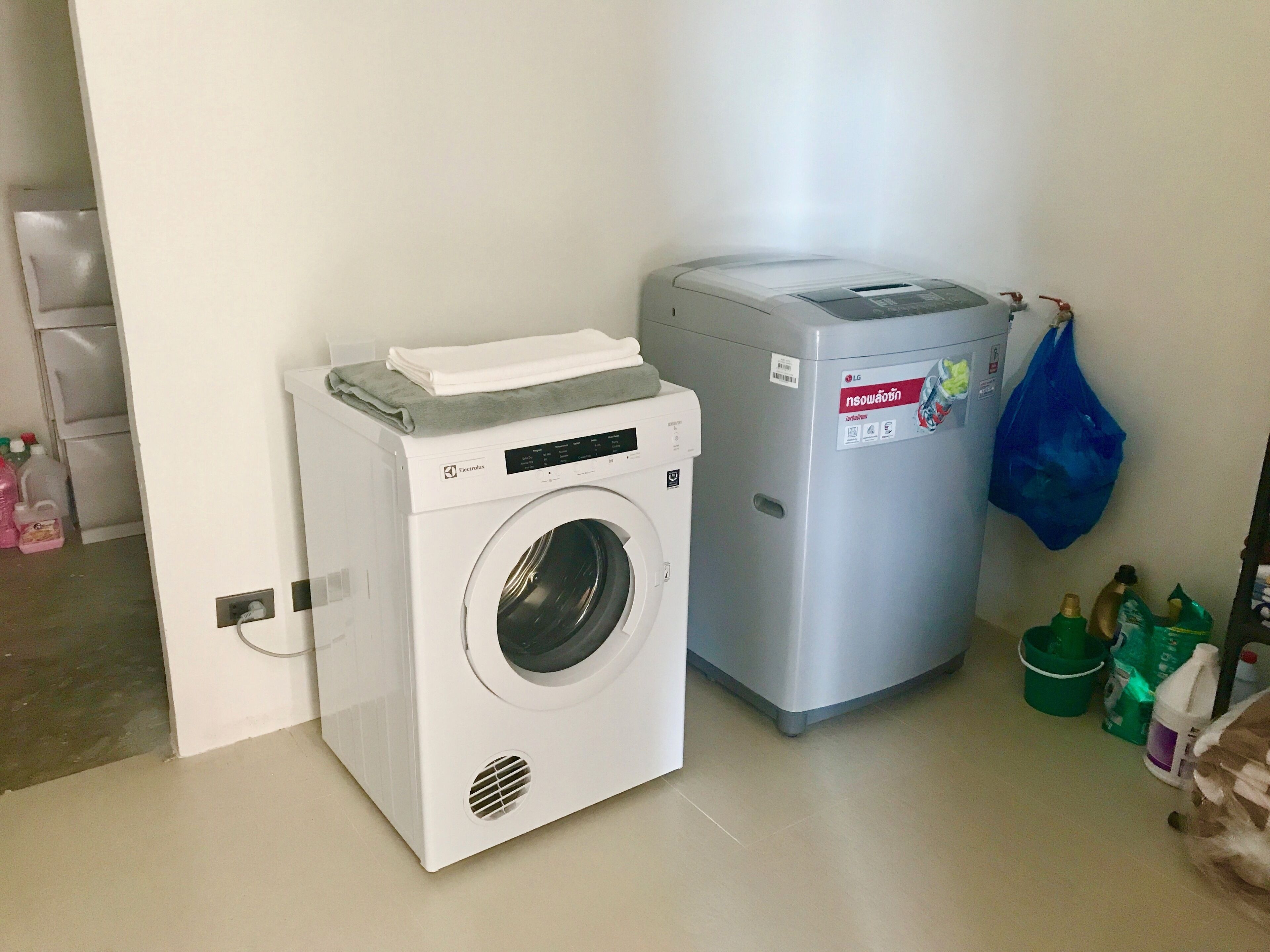 A compact laundry area with a front-loading washing machine and a stacked dryer.