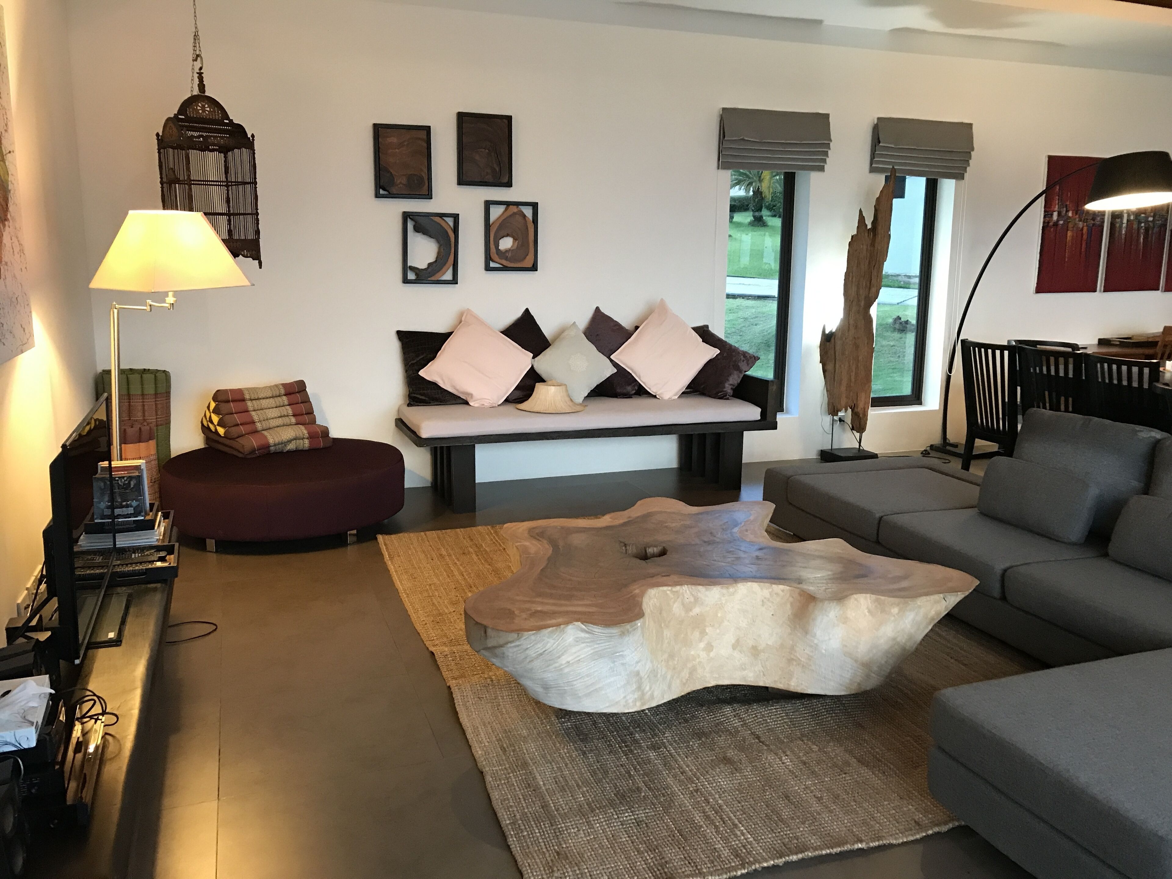 Una sala moderna con sofá, reposapiés, mesa de centro y una obra de arte en la pared.