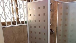 Un baño pequeño con inodoro, cabina de ducha de vidrio y barra para toallas.