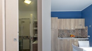 Een moderne keuken met houten kastjes, een betegelde achterwand en een wit aanrecht.