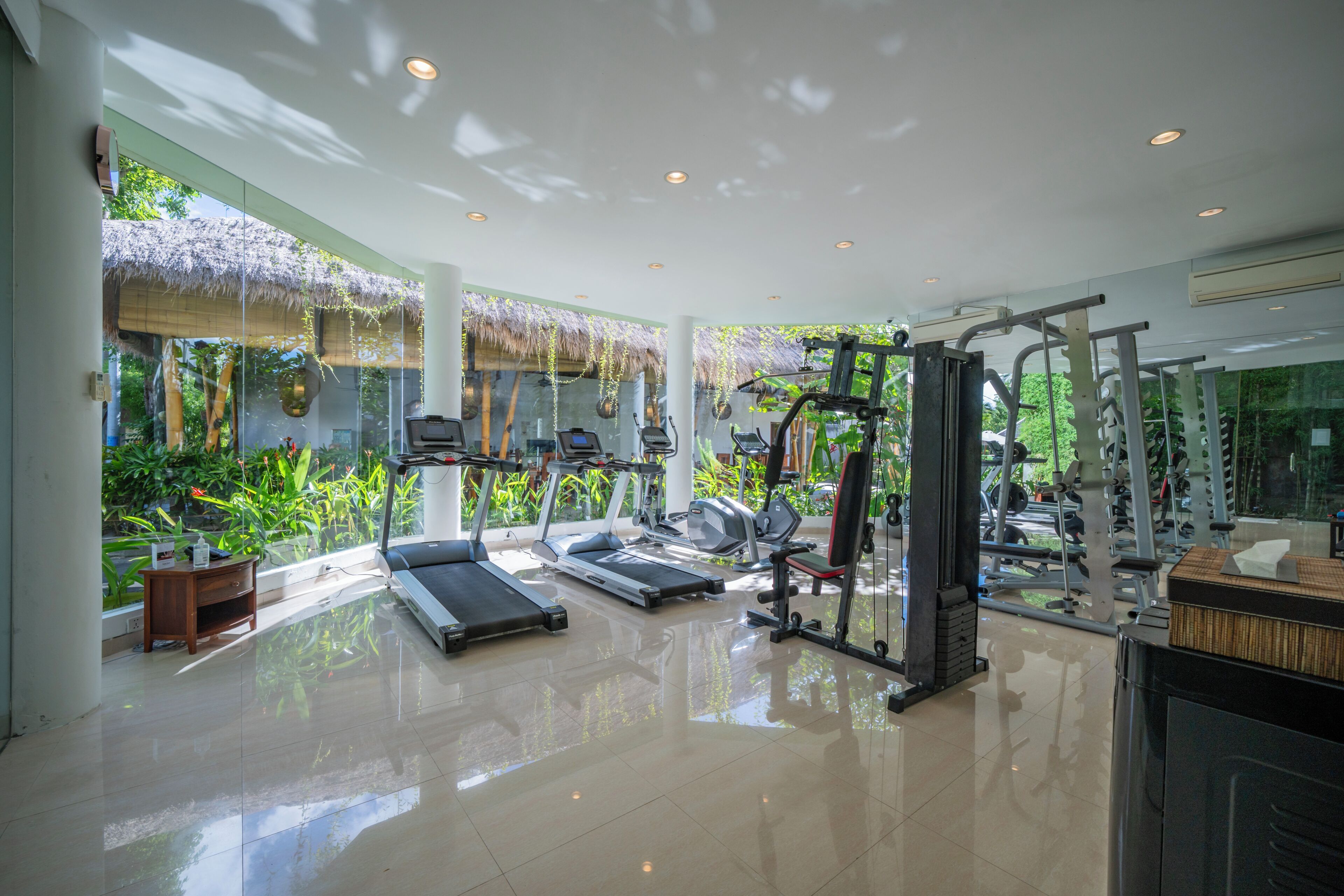 A gym with treadmills, elliptical machines, and weightlifting equipment.